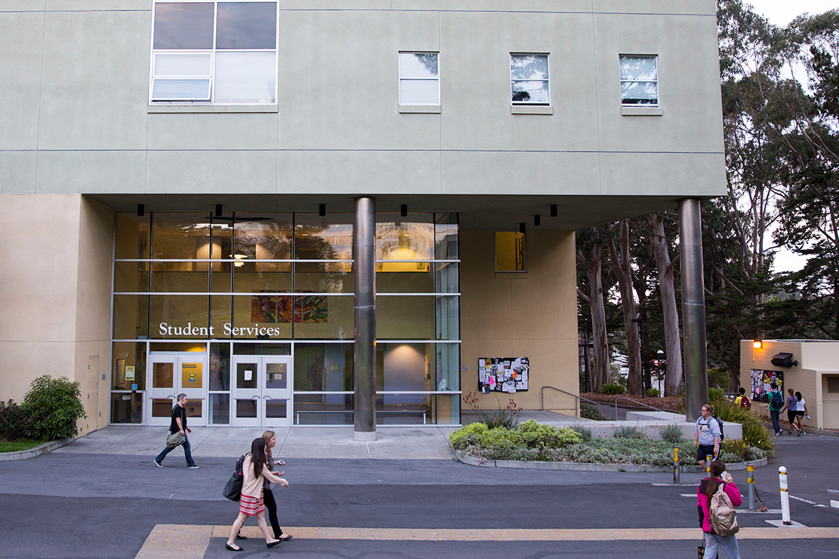 Front of Student Services building with students walking past